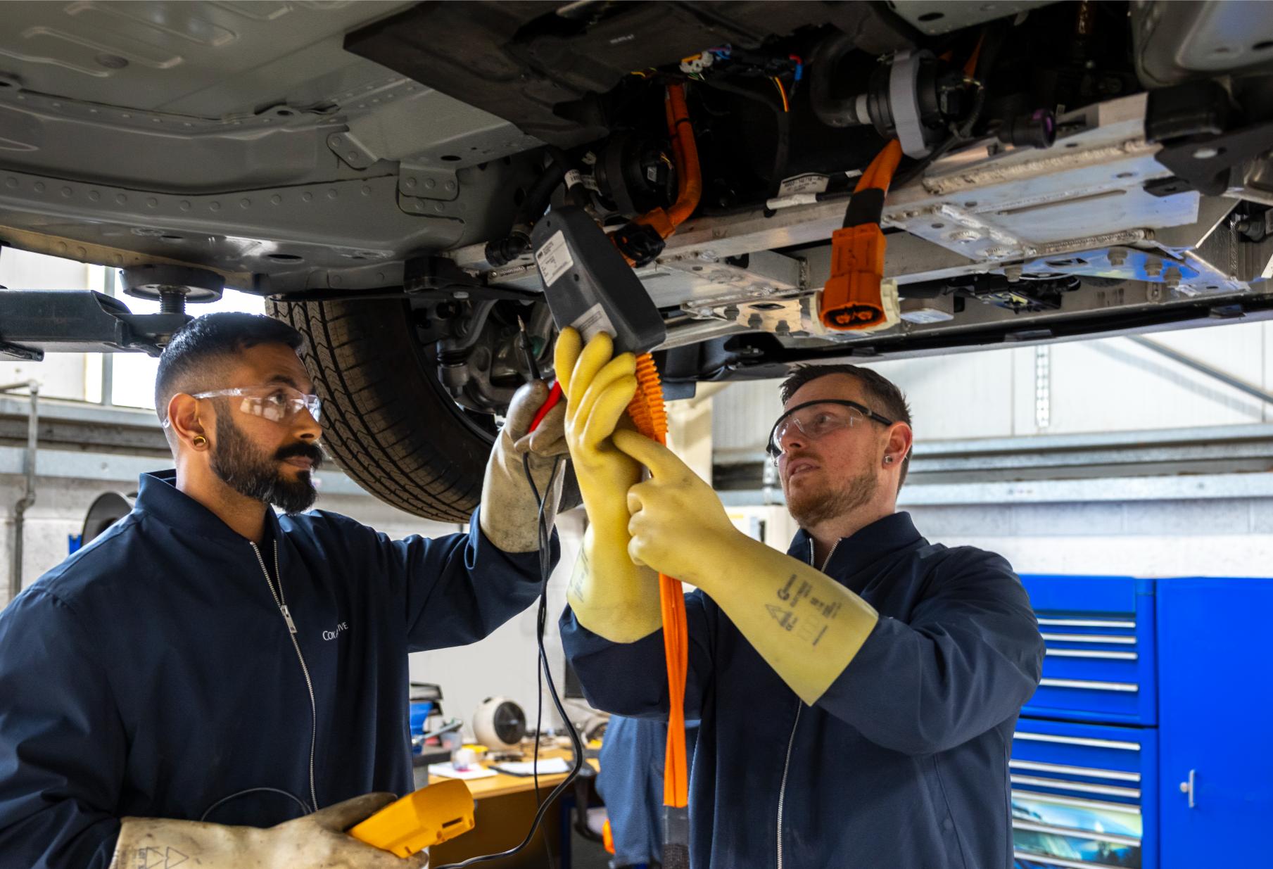 Two men working on an EV