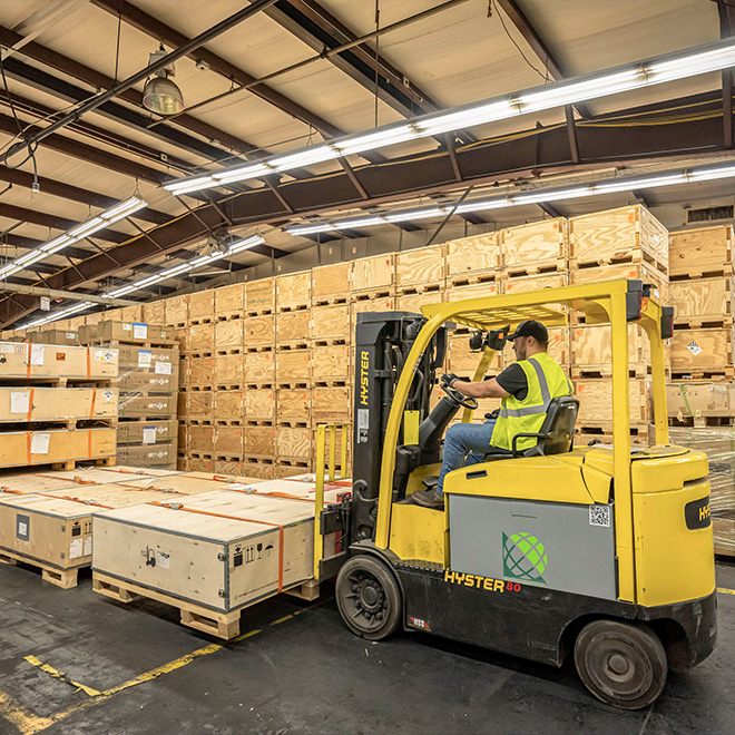 A man driving a forklift at the EVBS workshop.