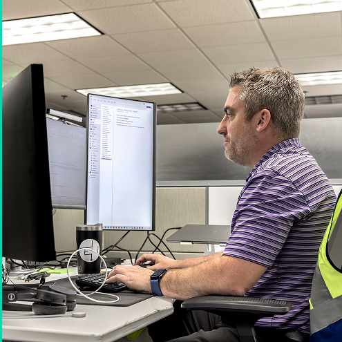 An EVBS team member behind a desk working at a computer. 