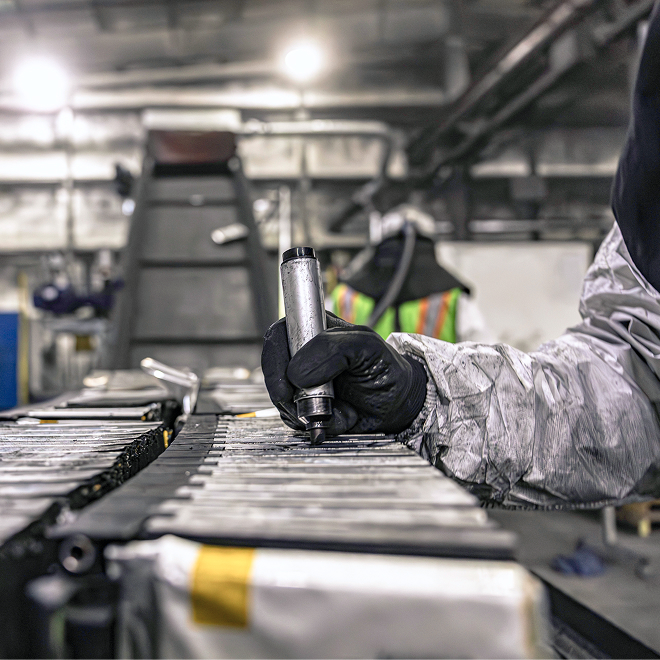 a worker carrying out a stage of the ev battery recycling process
